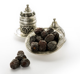 Dates Next to Arabic Coffee / Turkish Coffee - organic dates over white background - Bowl of dried dates isolated on white background