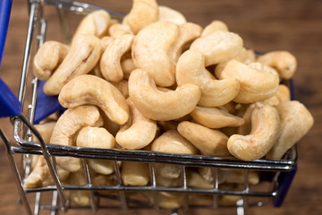 Cashew nuts on miniature shopping cart with close up shot.