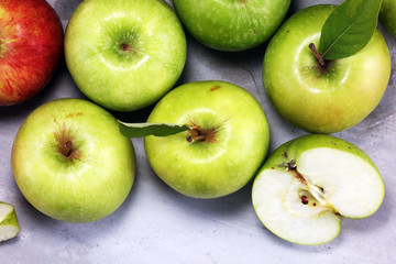 Ripe red apples with leaves on wooden background.