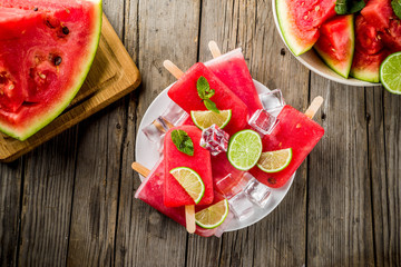 Sweet summer watermelon and lime popsicles with sliced watermelon and mint, on white marble background copy space