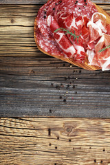 Food tray with delicious salami, ham,  fresh sausages and herbs. Meat platter with selection