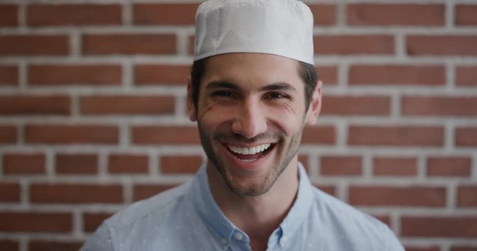 portrait attractive young muslim man laughing enjoying successful lifestyle happy independent male wearing kufi hat slow motion