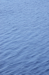 Obraz premium Vertical ocean water waves background pattern, abstract blue gentle bokeh bright ripples texture, scenic vibrant seascape summer season surface, large detailed copy space wallpaper