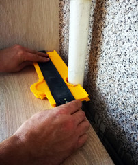 a man using a template to outline the contours draws the size for the details