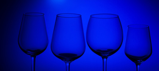 Row of wine glasses on blue background, banner