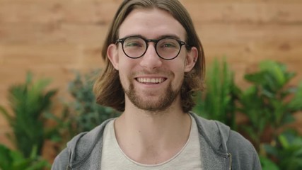 portrait of cute young geeky man wearing glasses smiling happy enjoying relaxed lifestyle