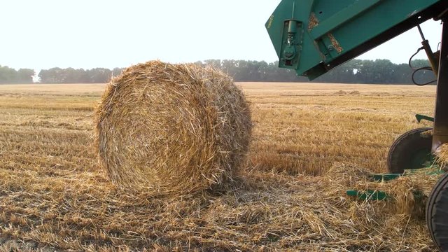 Tractor making hay bales. combine Harvester swathing a crop.