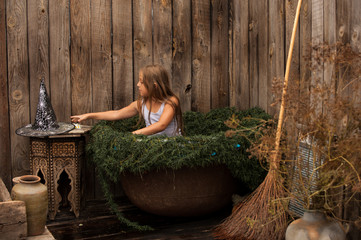 Young witch flew on broom in secluded place to plunge into cauldron with decoction of rejuvenating...