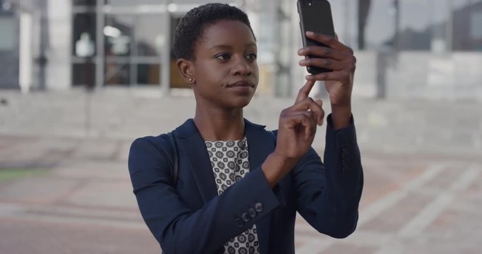 portrait successful african american business woman using smartphone taking photo in city sharing travel photography on mobile phone