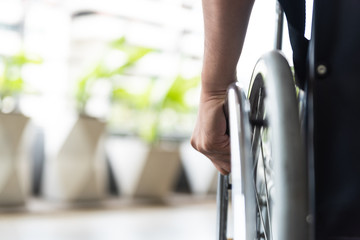 closeup disabled man hand on wheel of wheelchair