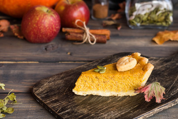 Traditional homemade American pumpkin pie with a decor of leaves and pumpkin seeds for a holiday