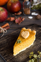 Traditional homemade American pumpkin pie with a decor of leaves and pumpkin seeds for a holiday