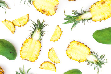 Tropical pattern of pineapple and mango fruits on white background. Flat lay, top view. Food...