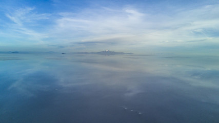 Fototapeta na wymiar Aerial Uyuni reflections are one of the most amazing things that a photographer can see. Here we can see how the sunrise over an infinite horizon with the Uyuni salt flats making a wonderful mirror. 