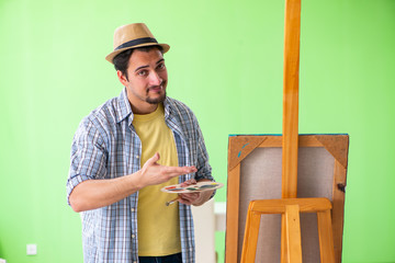 Young male artist working on new painting in his studio