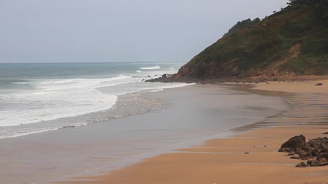 
Las olas llegando a un sector extremo de la playa con pun puntal cubierto por algo de bruma