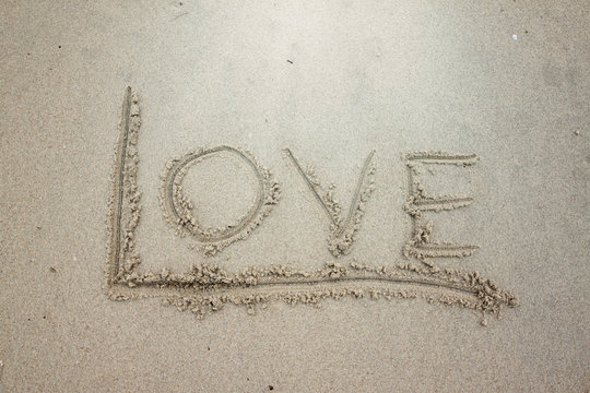 Write the word love on the sand.