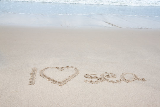 Write the word I Love Sea with wave on the beach.