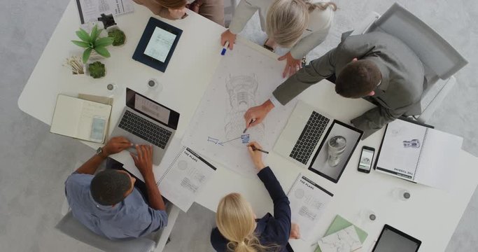 diverse business people engineers planning turbine project brainstorming working on design schematics in corporate boardroom meeting using 3d render overhead