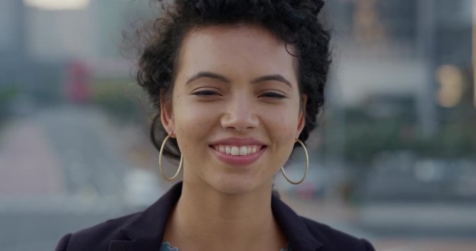 portrait beautiful young hispanic business woman laughing enjoying successful urban lifestyle in city wearing stylish earrings slow motion