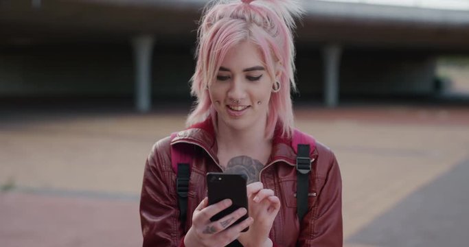 portrait young caucasian woman pink hair using smartphone texting enjoying browsing sms messages on mobile phone communication app real people series
