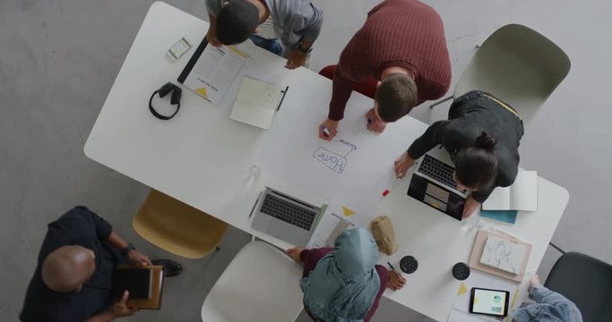 multi ethnic team of web developers brainstorming ideas for startup business website planning design layout in modern office workplace top view