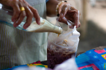 pouring coca cola or pepsi fresh sweet water in ice bag in market .