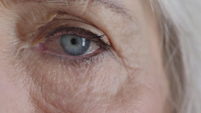 close up beautiful old woman eye looking at camera blue iris