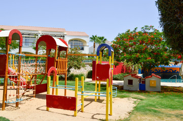 A cheerful children's playground with slides of sand puddles playing games and designs in an exotic...