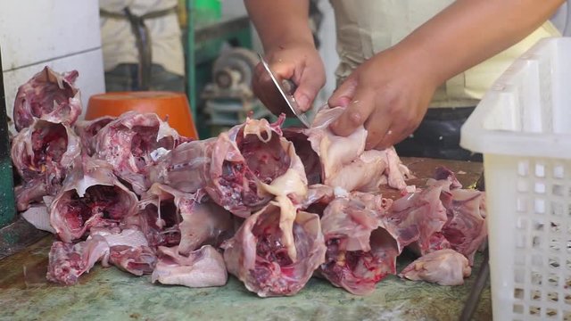A man filleting a broiler using cleaver