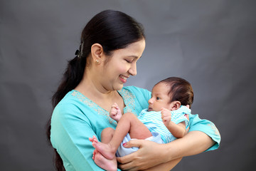 Cheerful mother holding newborn baby - 215449956