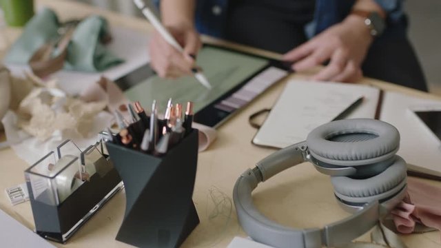 close up young fashion designer woman sketching in startup company working designing stylish clothes drawing using tablet technology successful female entrepreneur