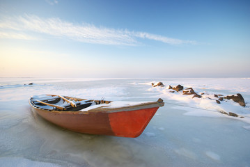Boat on ice and winter landscape nature composition.