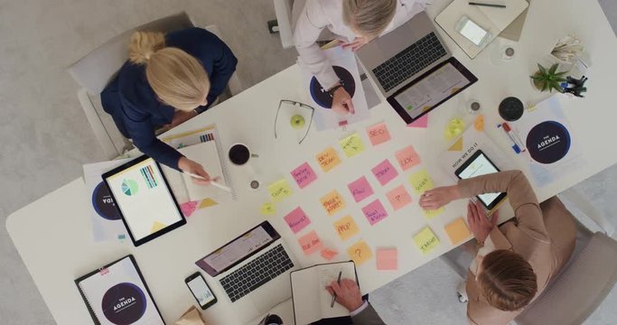 group of diverse business people working together brainstorming strategy for innovative company making notes using colorful paper in boardroom meeting top view