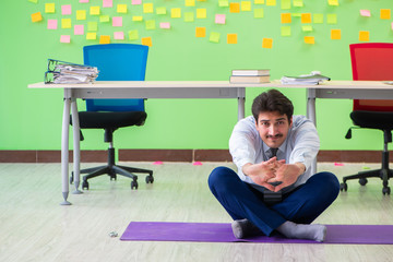 Man in the office with many conflicting priorities doing exercis