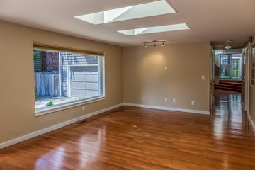 empty living room with wood floors and beige walls