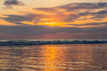 Sunset on the Kuta beach with reflection in the water on the island of Bali