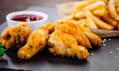 Chicken nuggets with french fries on black stone plate