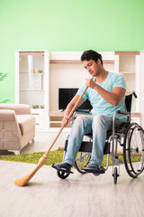 Fototapeta na wymiar Disabled man on wheelchair cleaning house