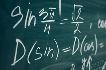 Trigonometric equation written on the chalkboard. School curriculum.