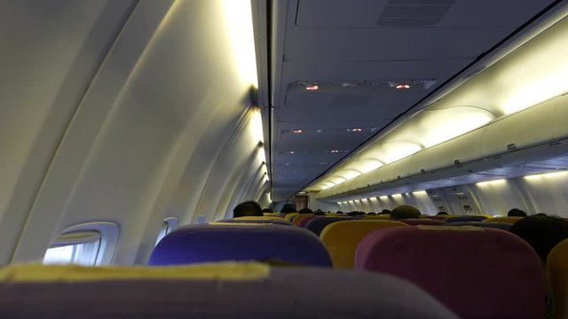 back of passenger sit in Aircraft cabin inside commercial airline.