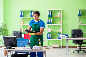 Male handsome professional cleaner working in the office