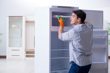 Man cleaning fridge in hygiene concept