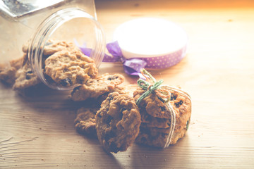 freshly baked chocolate chip cookies with plastic box package on wooden table