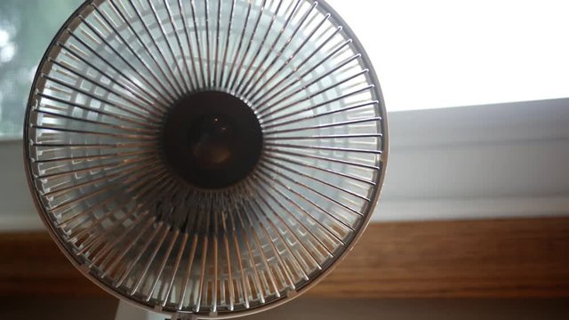 Close up of desktop fan blowing and rotating towards camera V3