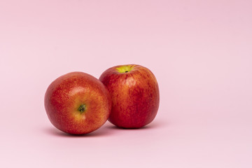 Red whole apples isolated on pink background