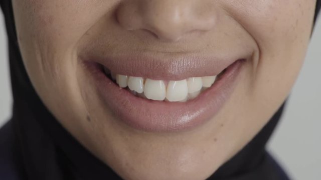 close up woman mouth smiling happy satisfaction middle eastern female wearing hijab healthy teeth