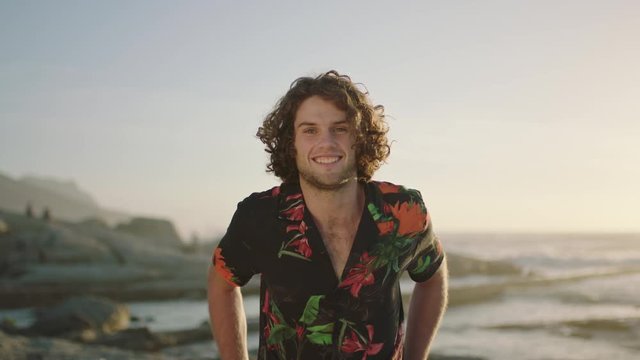 portrait of attractive young man smiling confident at beach wearing  aloha shirt