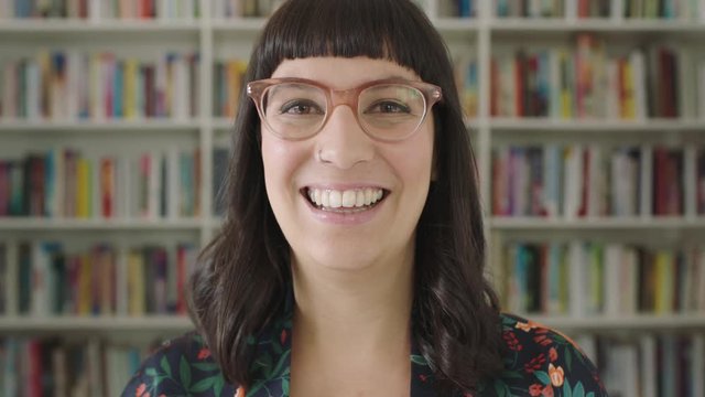 Portrait young woman student smiling bookshelf library university