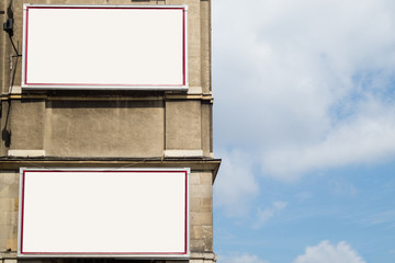 Two empty advertising billboards on the wall of building